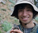 scientist in field with frog